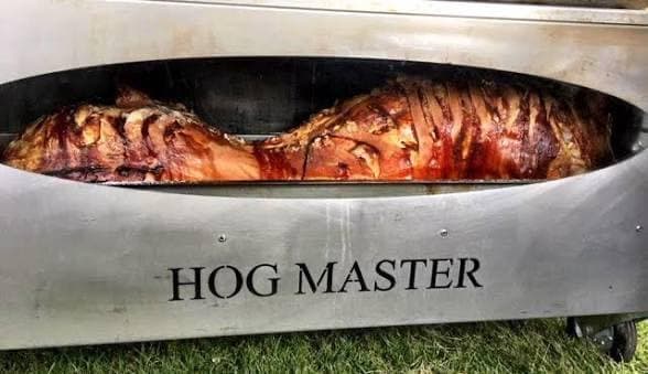 A Hog Master trolley with a whole spit-roasted pork joint ready for carving at a function.